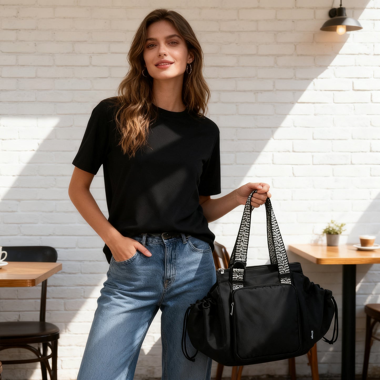 Woman holding a black handbag in an outdoor cafe setting